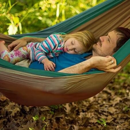 Hamaca para jardín con padre e hija acostados.